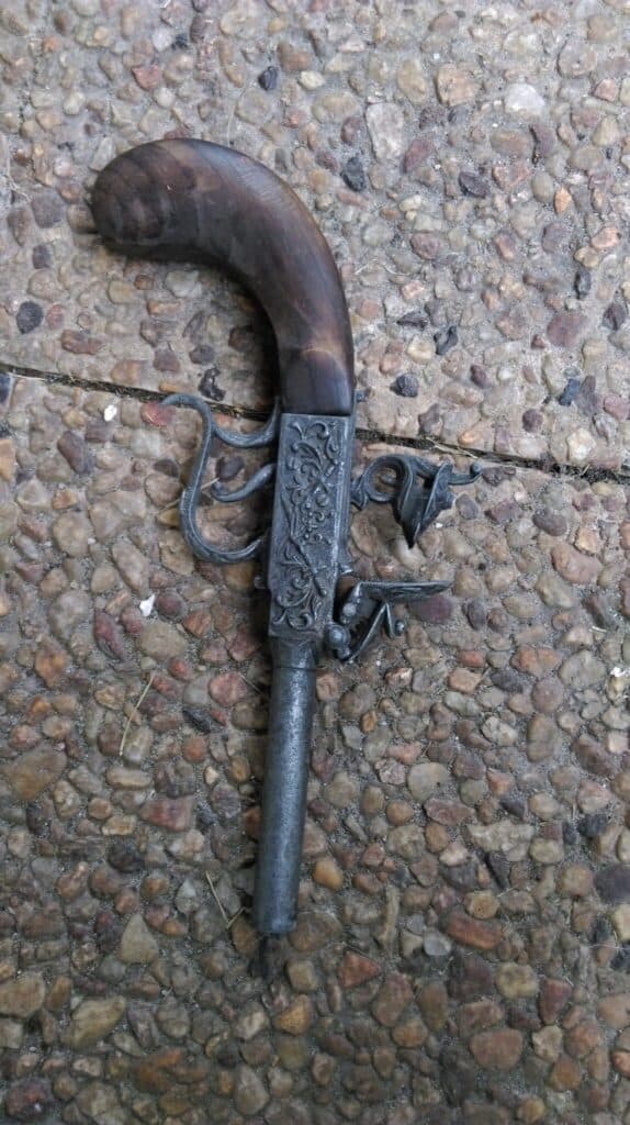 Pistola visiblemente antigua con culata de madera