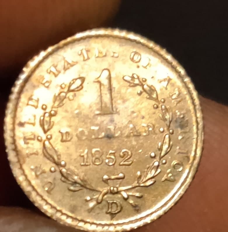 Tasación de una moneda estadounidense de un dólar de 1852 en excelente estado